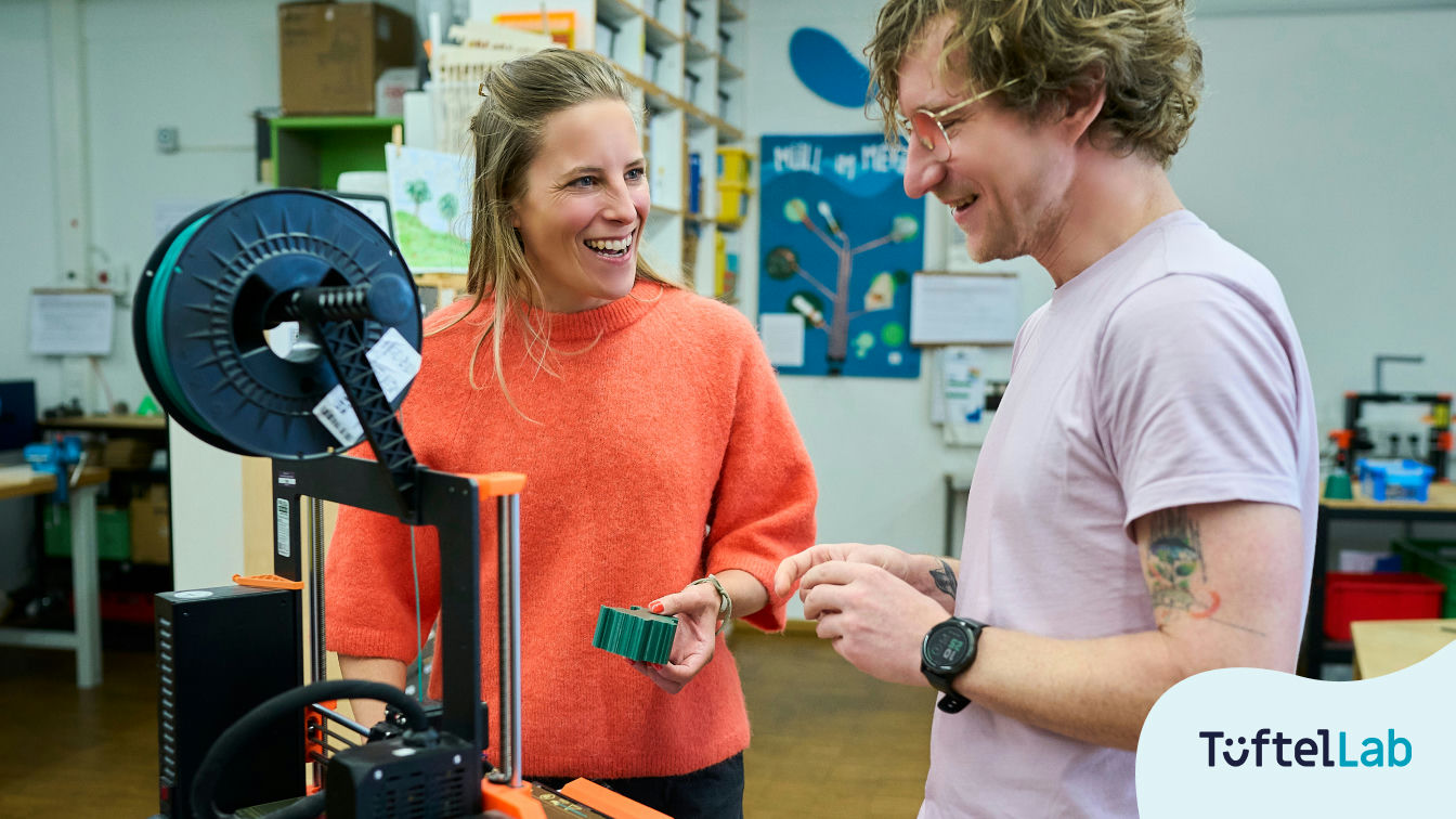 Zwei Personen stehen am 3D Drucker