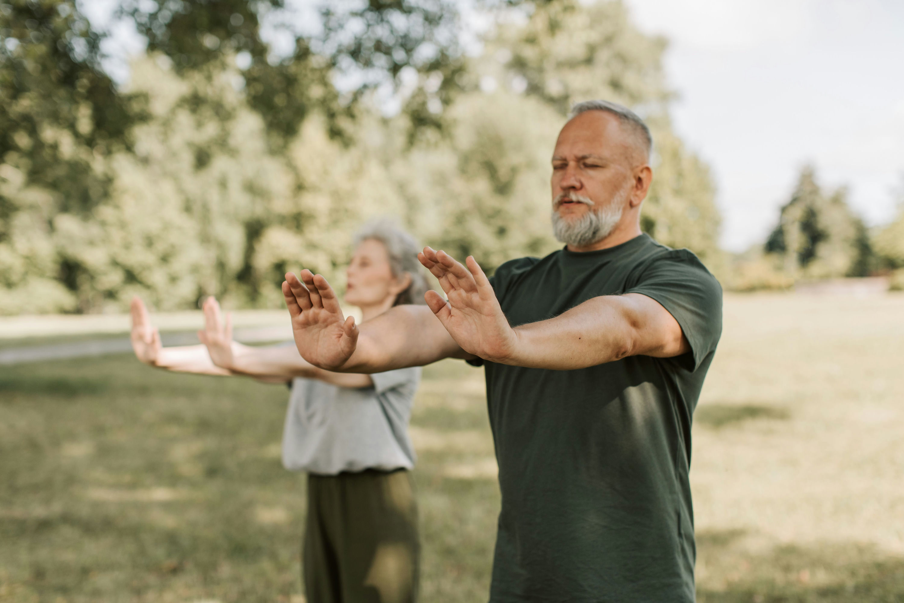Älteres Paar praktiziert Qi Gong im Freien