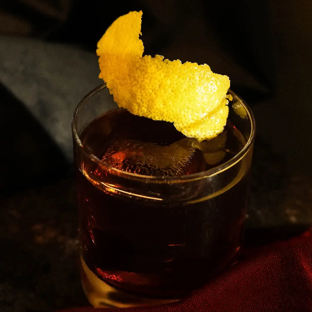 Non-alcoholic Black negroni cocktail on a dark background