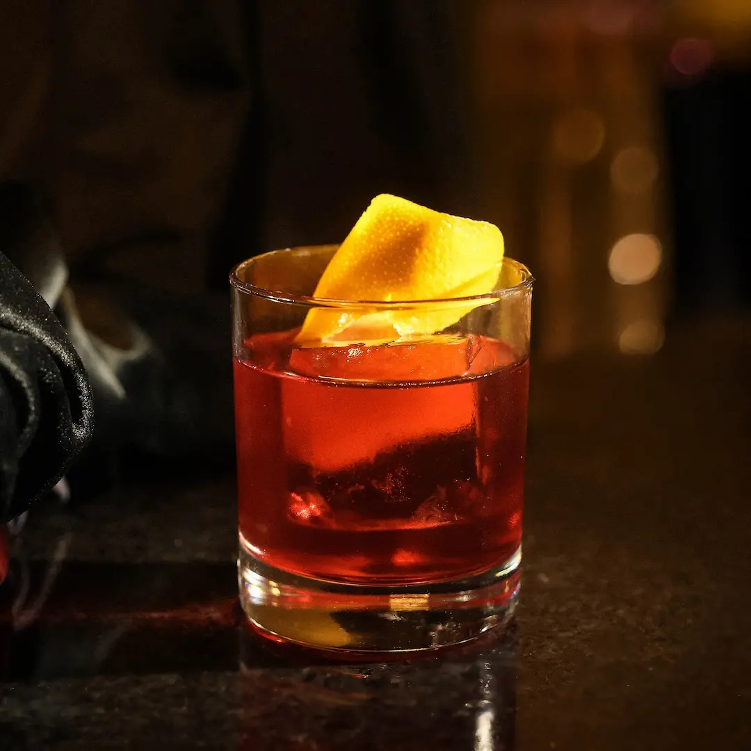 Non-alcoholic Negroni cocktail on a table and a dark background
