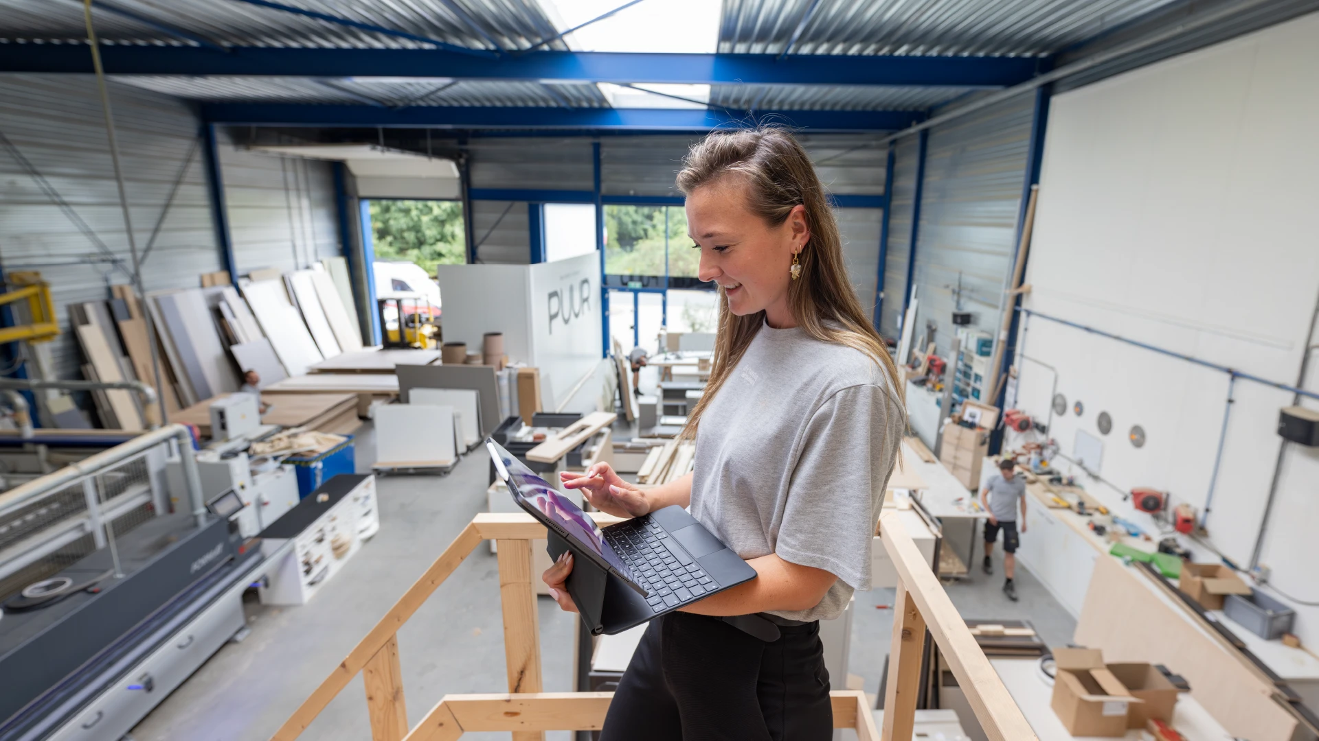Medewerker gebruikt vPlan op laptop in productieomgeving om planning en voortgang in de werkplaats te beheren.