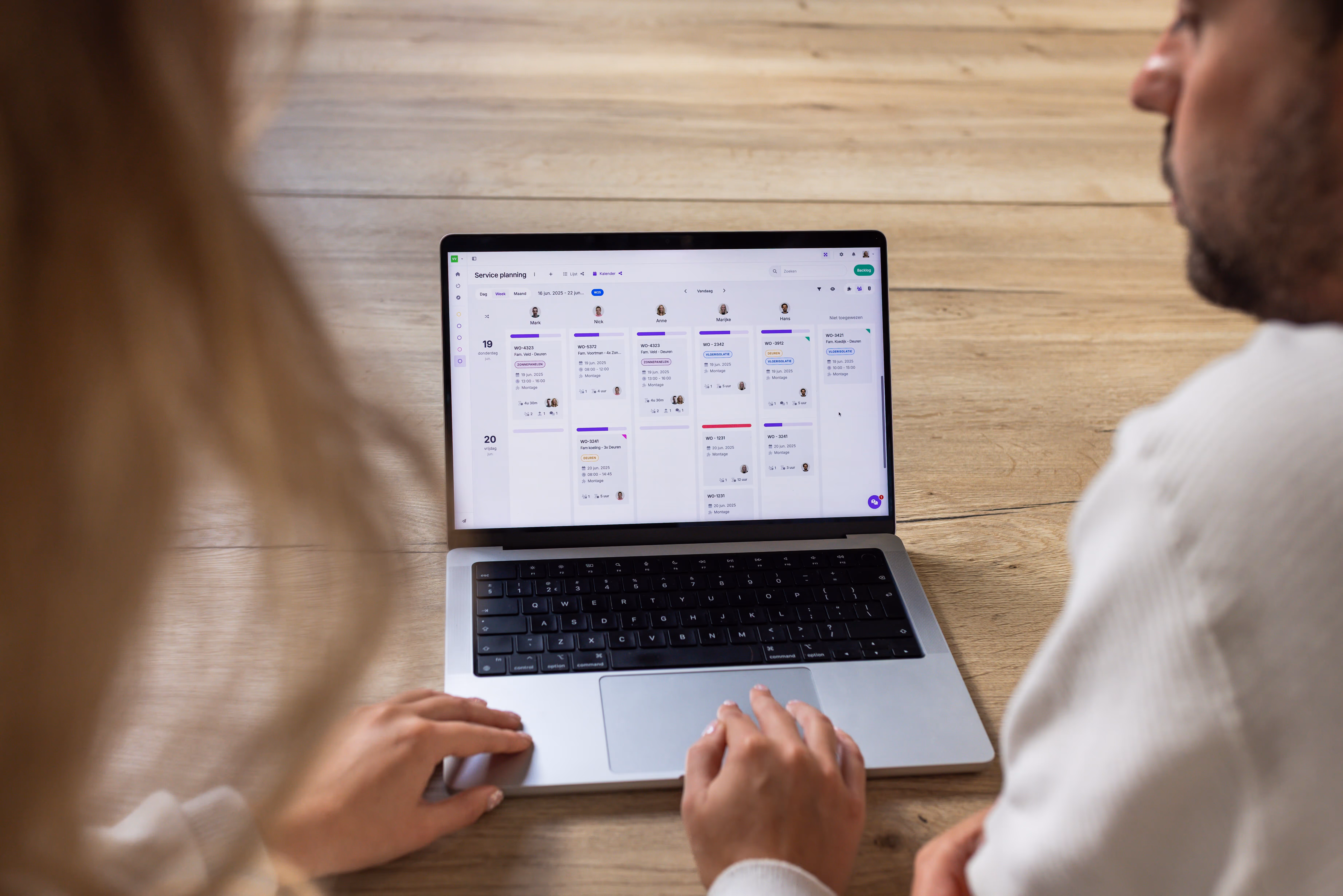 Two colleagues working on a laptop within the listview of vPlan.