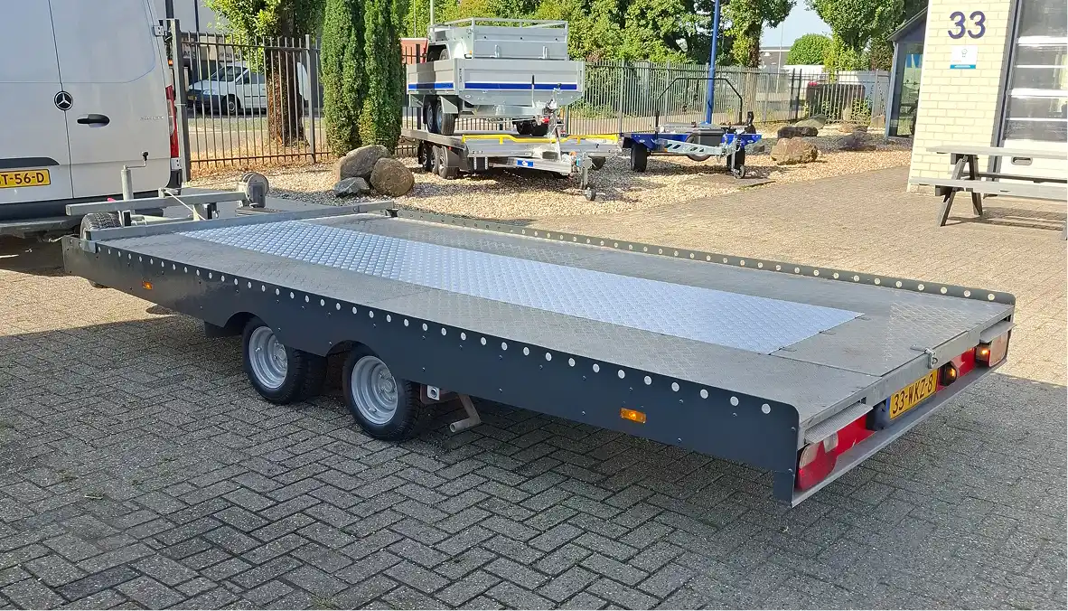 Auto-ambulance achter bus van Roefs Trailers