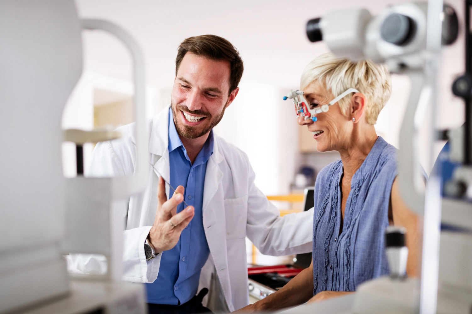 Optometrist performing eye exam on senior woman