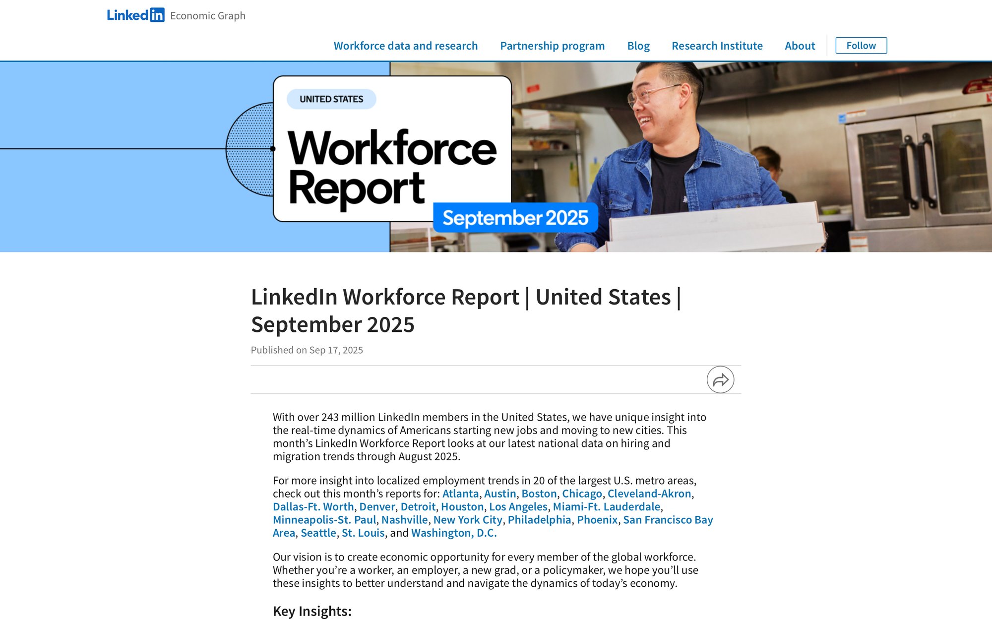 A man smiles while holding boxes in a professional kitchen, illustrating LinkedIn's September 2025 Workforce Report.