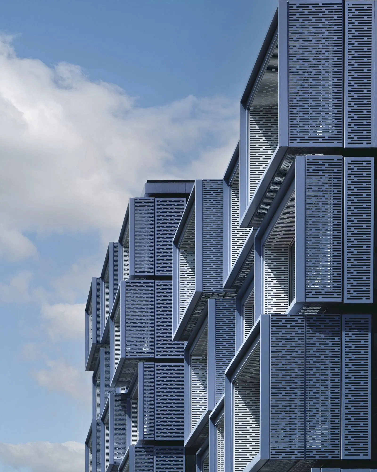 Cluster of geometric modern building facades with a cloudy sky