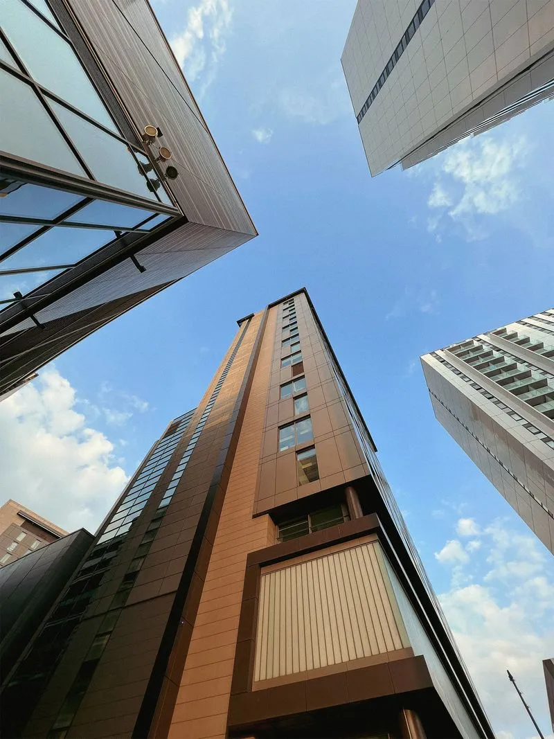 High-rise building with brown and beige exterior, viewed from below
