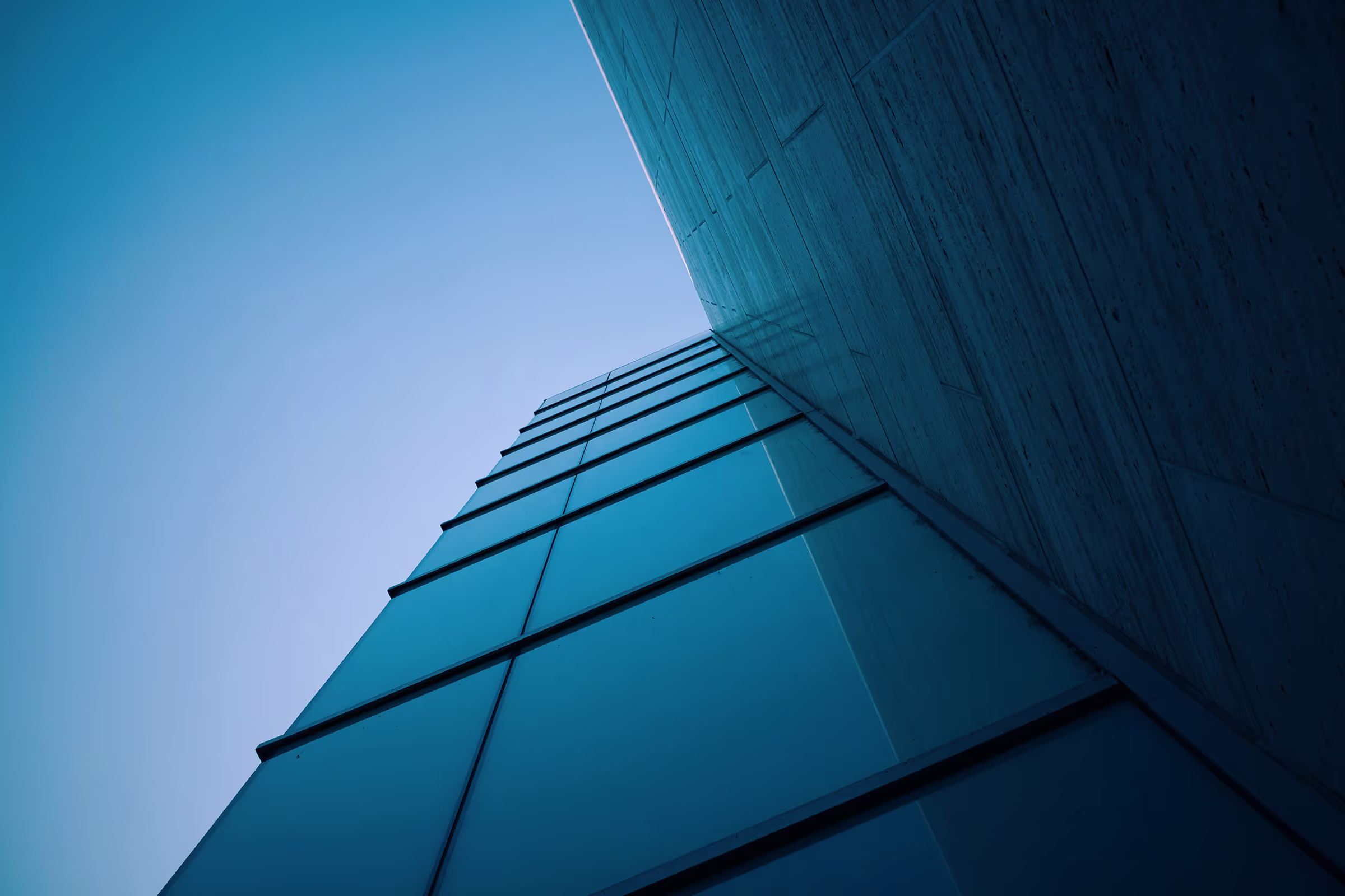 View of a building facade with glass windows, looking upwards