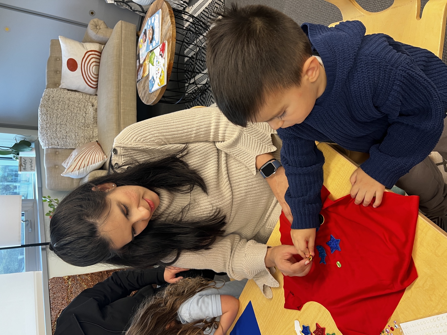 Child decorates a Super Sibling Cape with a caregiver