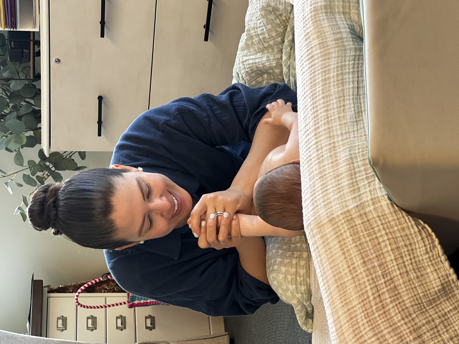 Caregiver practices infant massage with her baby