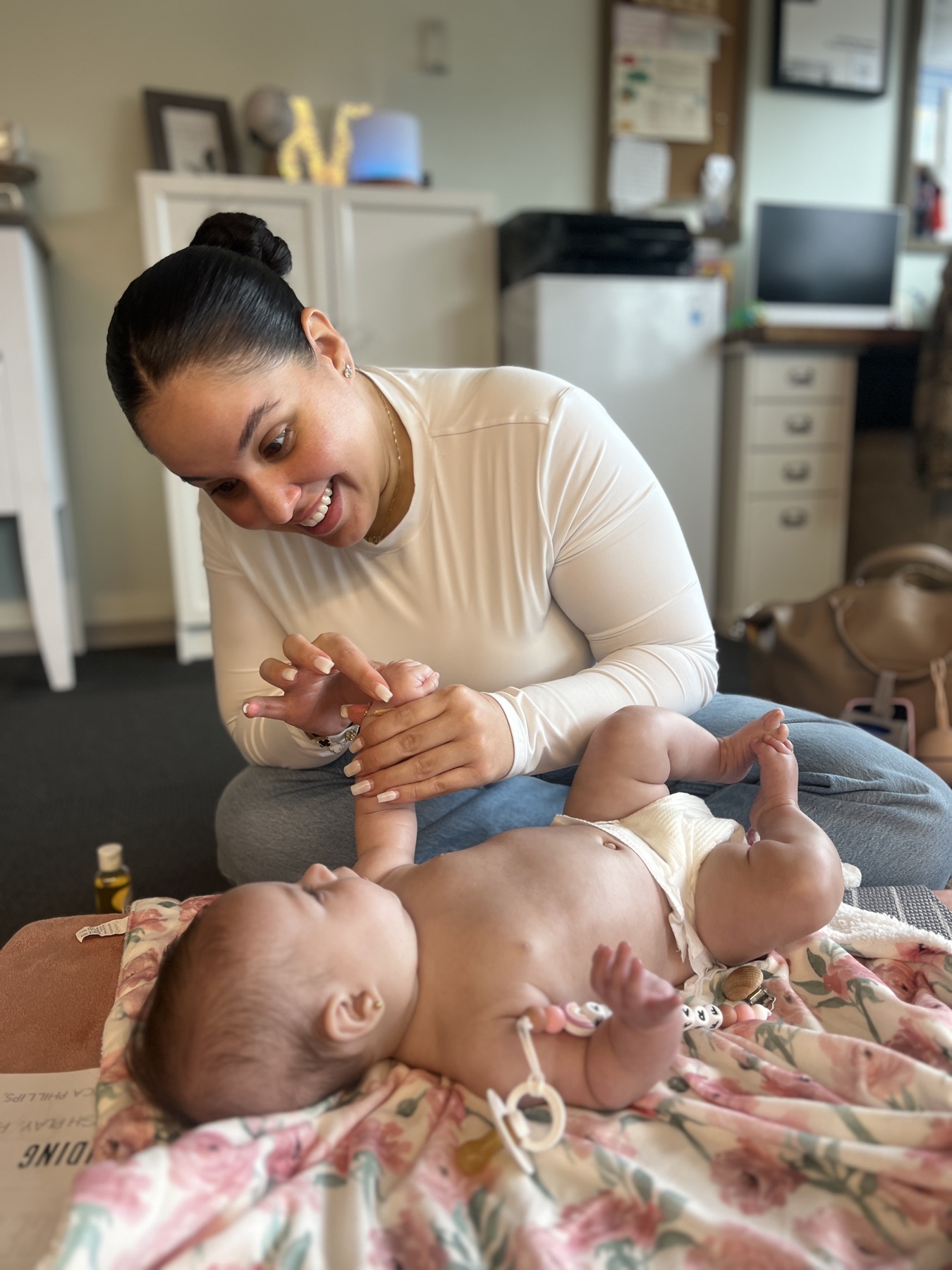 Caregiver gently massages her baby during class