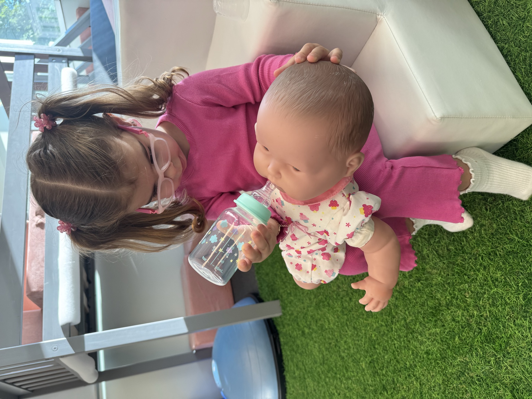 Young child practices caring for a baby doll