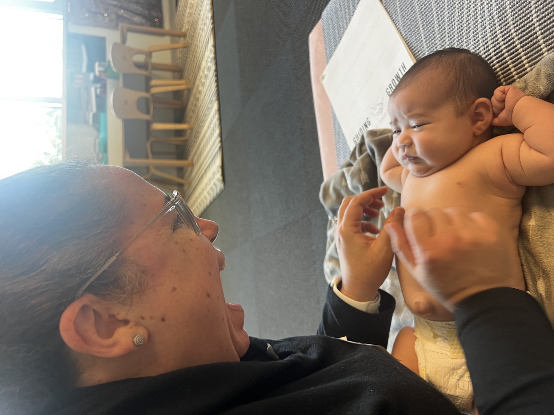 Caregiver follows guided massage techniques with her baby