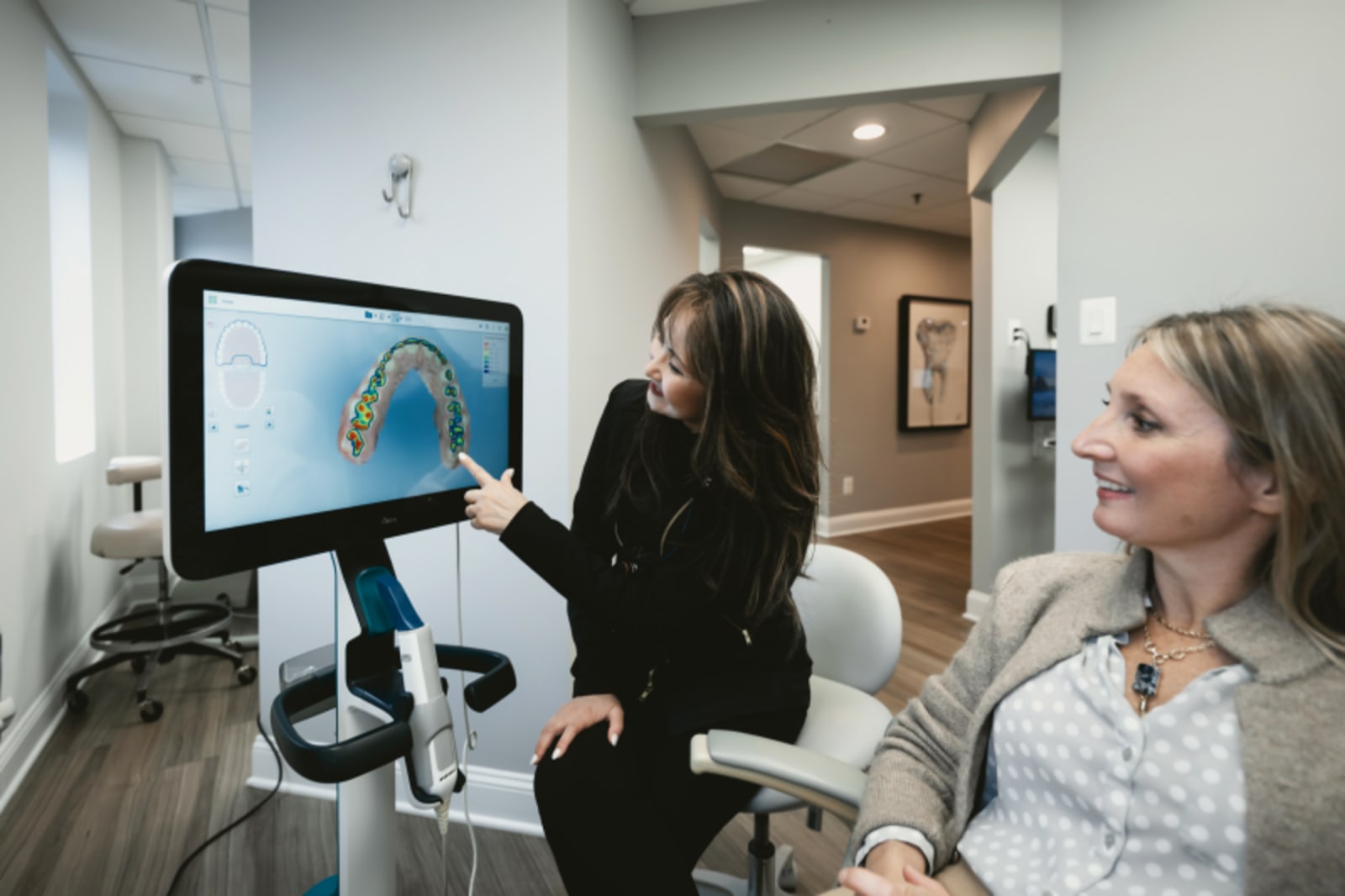 Dental team discussing treatment with patient while viewing scan on computer monitor in clinical setting