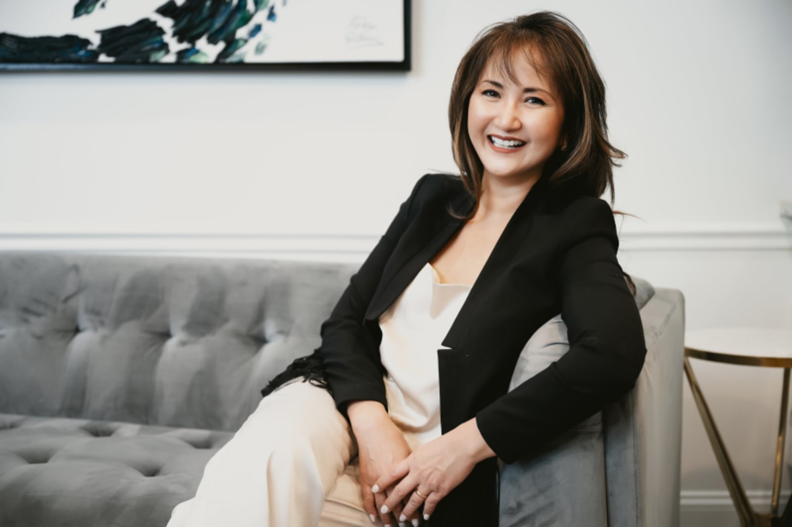 Professional female dentist in black blazer and white shirt, office setting
