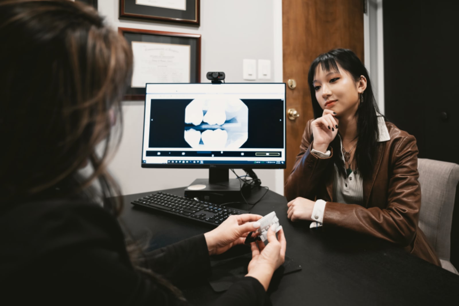 Dentist showing digital scan or treatment plan to patient at desk