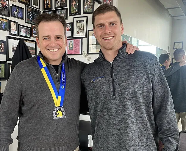bill with client wearing medal