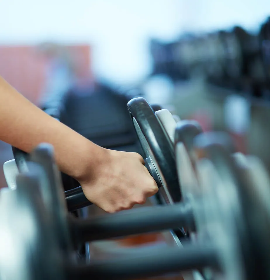 person grabbing dumbbells