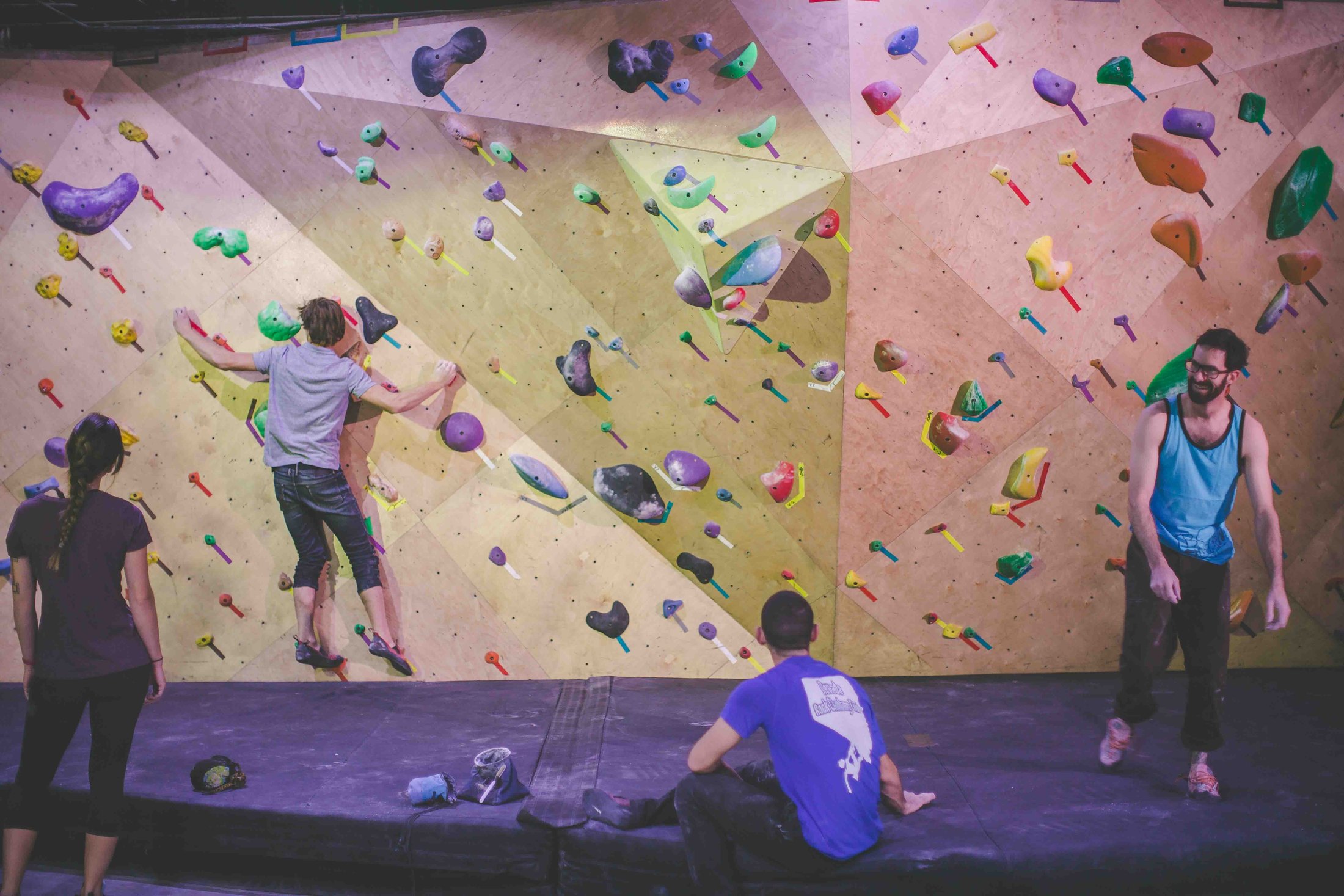 Climbers on the colorful indoor bouldering walls at BaseCamp
