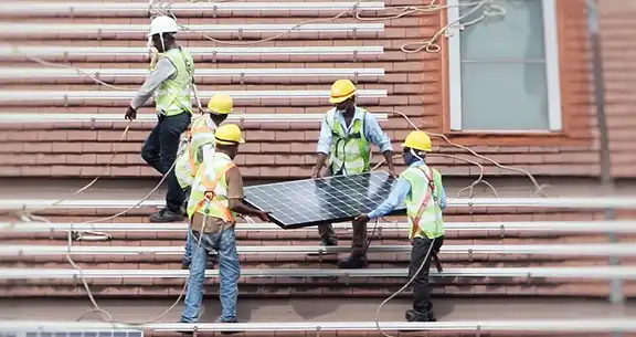 Workers holding solar panels