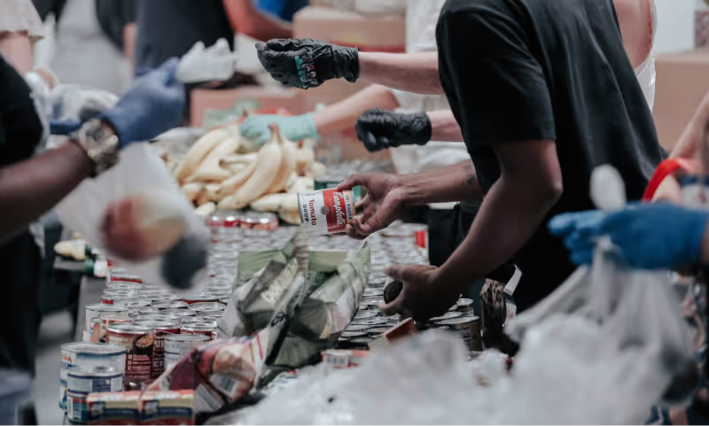 Volunteers handing food to people