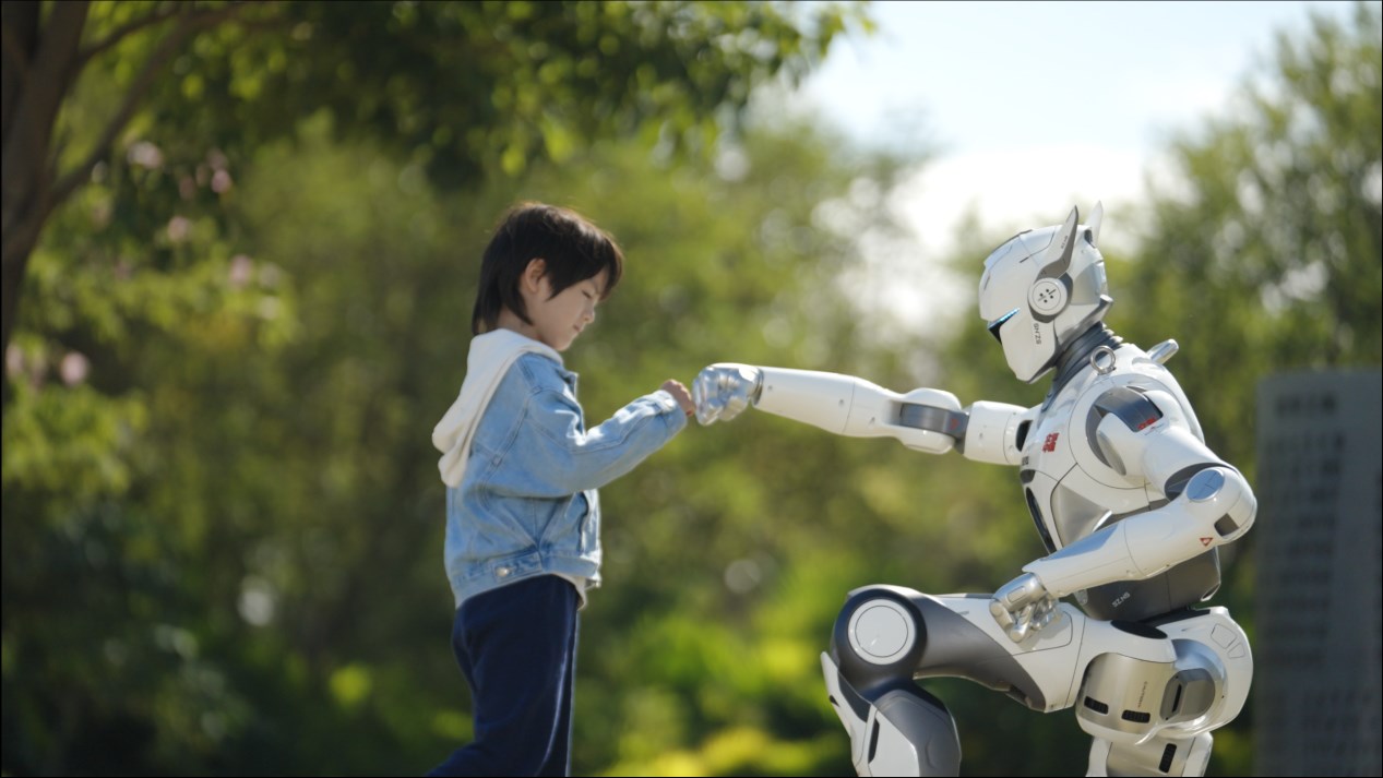 EngineAI T800 full-size humanoid robot outdoors, bumping fists with a child — 173 cm frame, 29 degrees of freedom