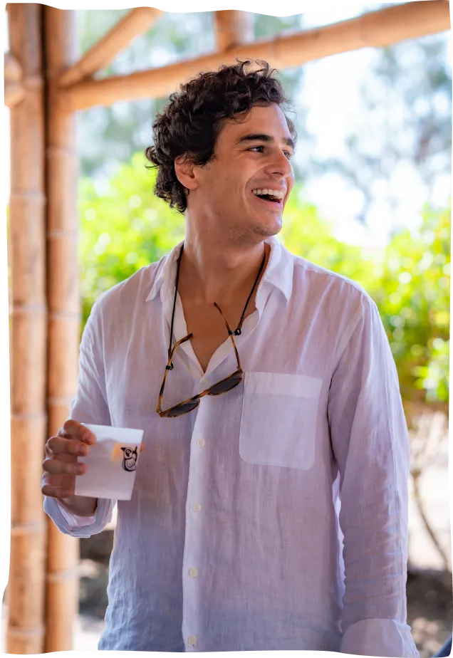 A man in a white shirt holding a cup.