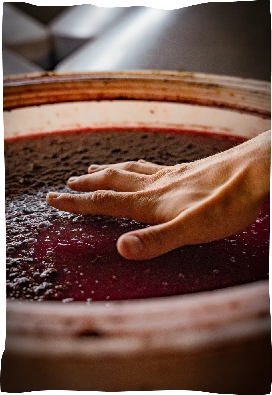 A close up of a person's hand on a pot of liquid.