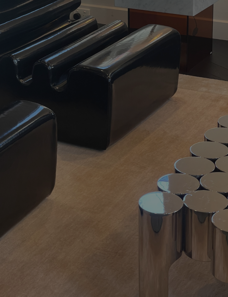 A modern living room featuring a chrome coffee table and black arm chairs industrial vintage 