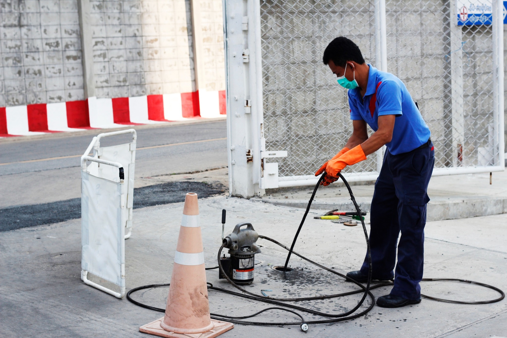 Plumber using a hydro jetting machine to clean a drain.