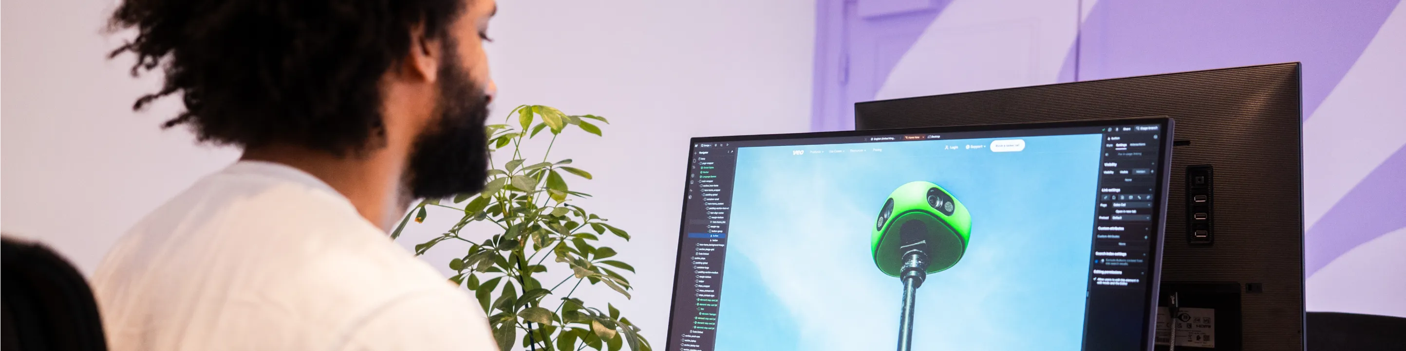 Person designing a website in Webflow, with a green device image on the screen.