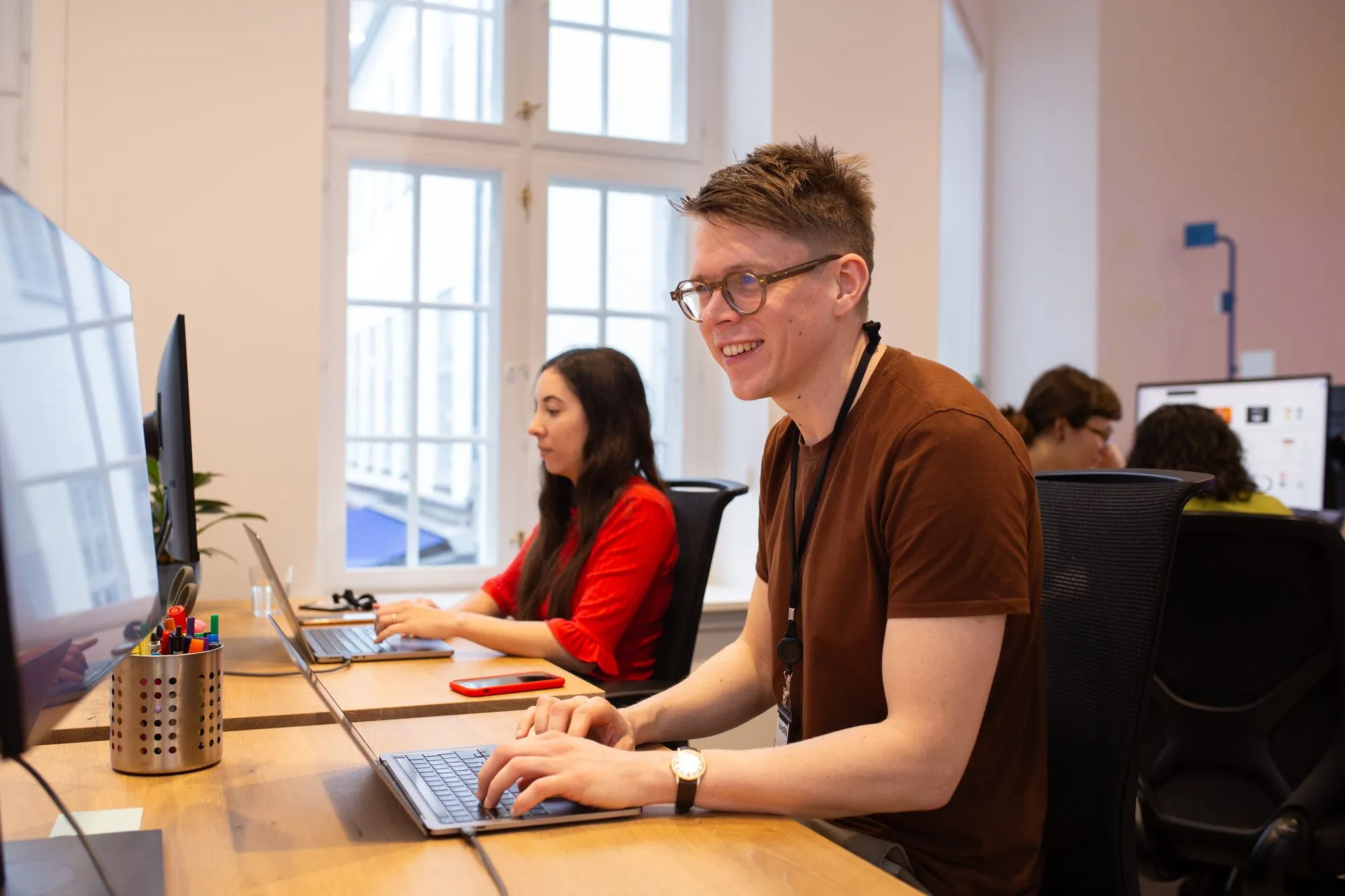 People working at desks in a bright, modern office.