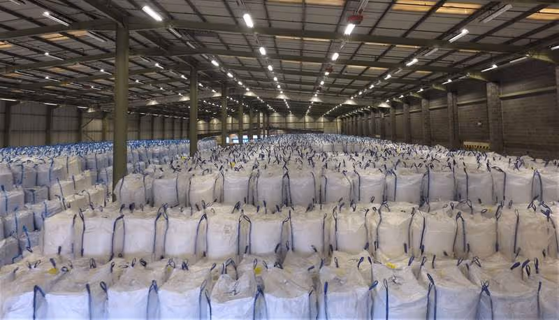 The interior of a large industrial building with hundreds of white bags next to each other