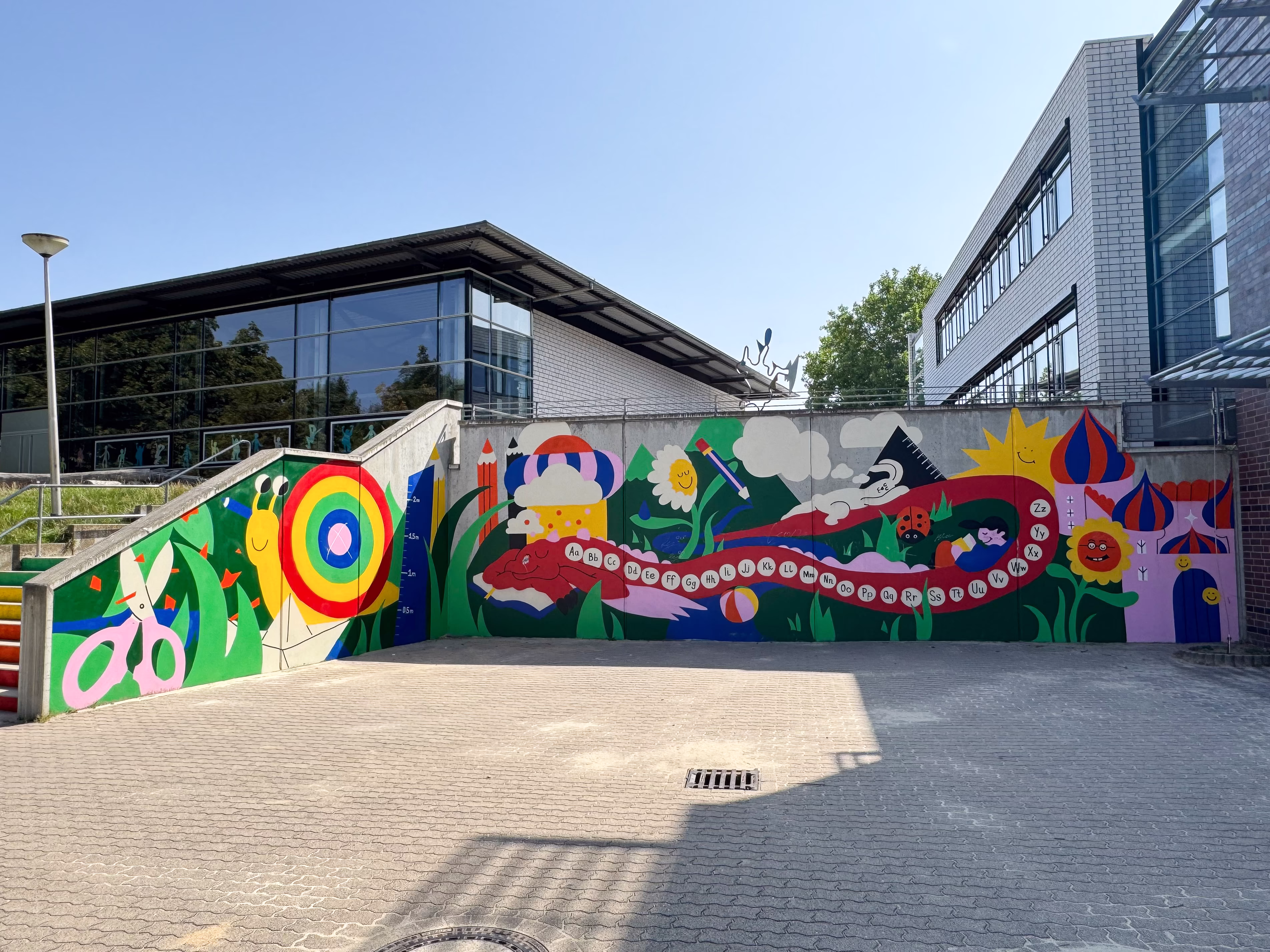 Grundschule Ochtersum: bunt bemalter Schulhof mit Spielfeldern und Mauer