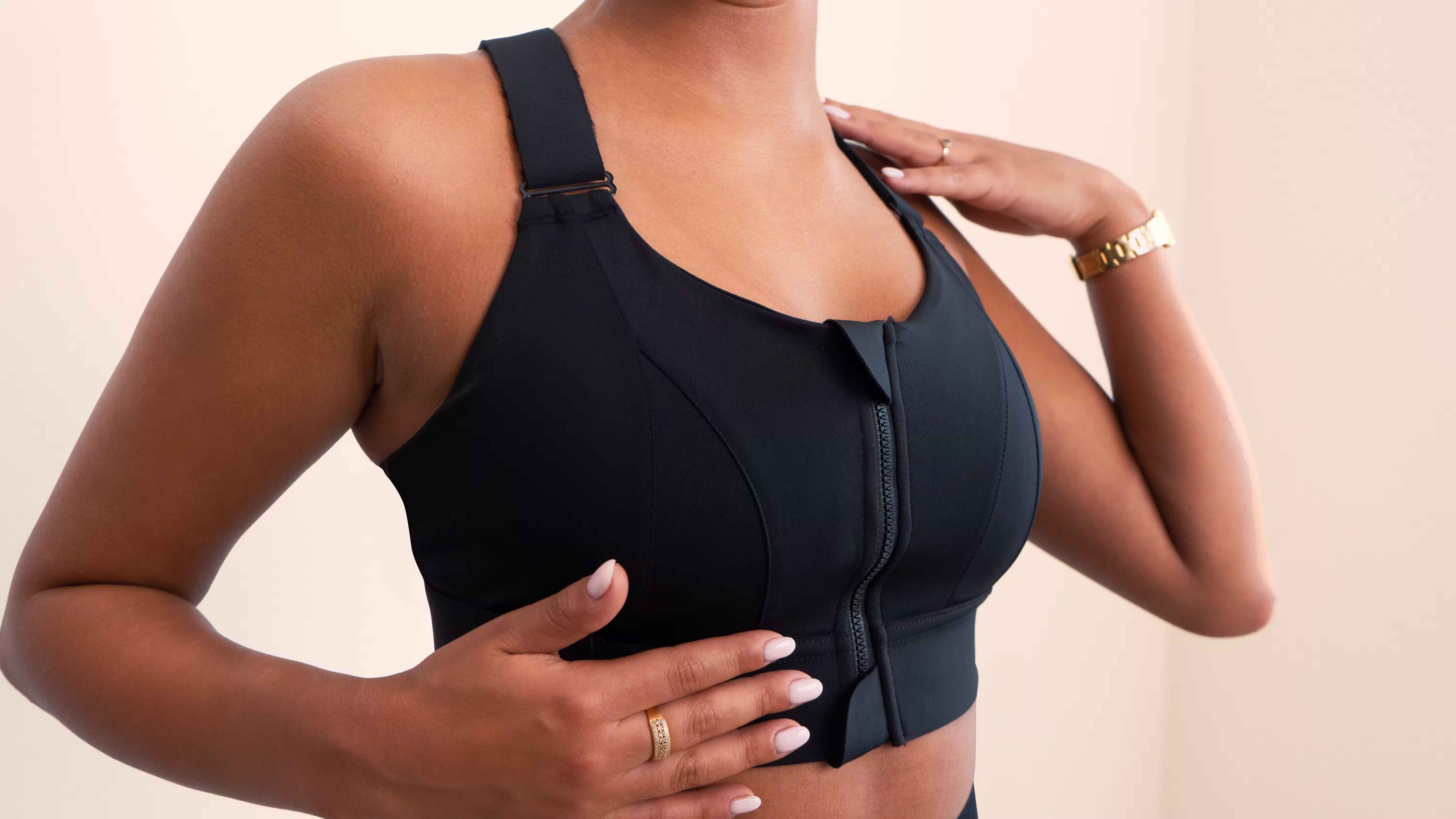 Close-up of a woman wearing a black Essie front-zip compression bra