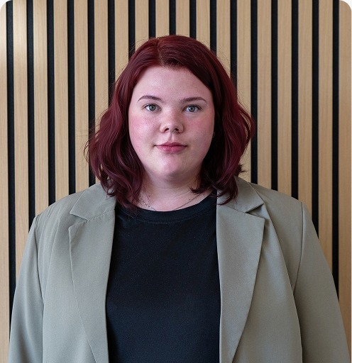 Vertriebsmitarbeiter Fiona Voigt sitzend in die Kamera schauend