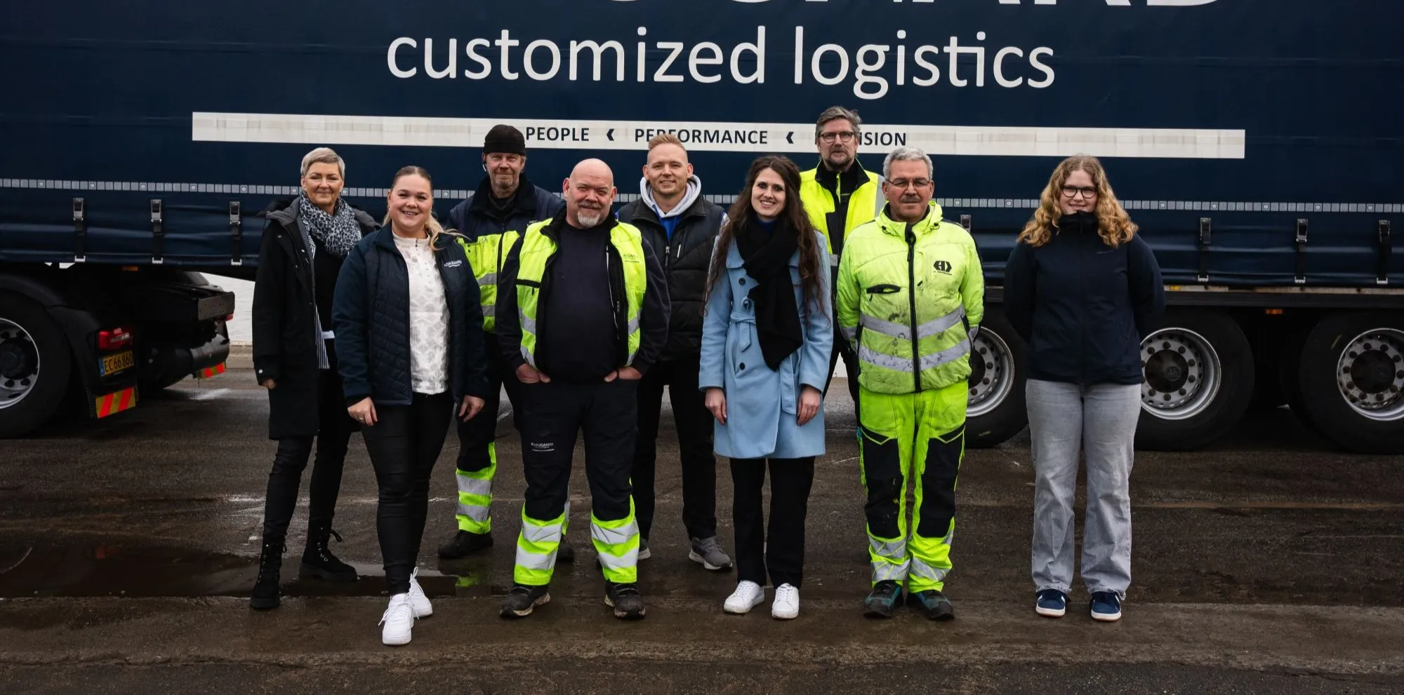 gruppebillede foran en lastbil