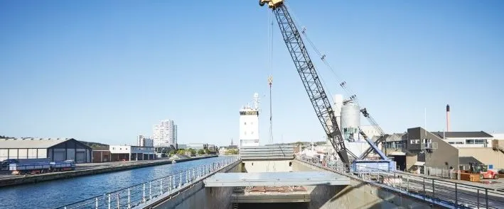 Kran ved havnekaj med industribygninger