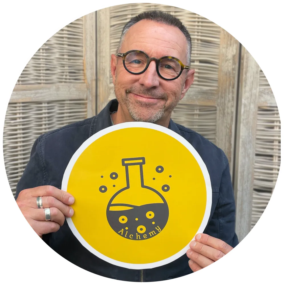 Chris Grimes holding yellow Alchemy sign representing Brand Strand and Founder Stories podcast