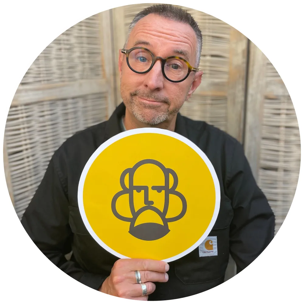 Podcast host - Chris Grimes - holding a yellow sign with the Legacy: Life Reflections logo inside