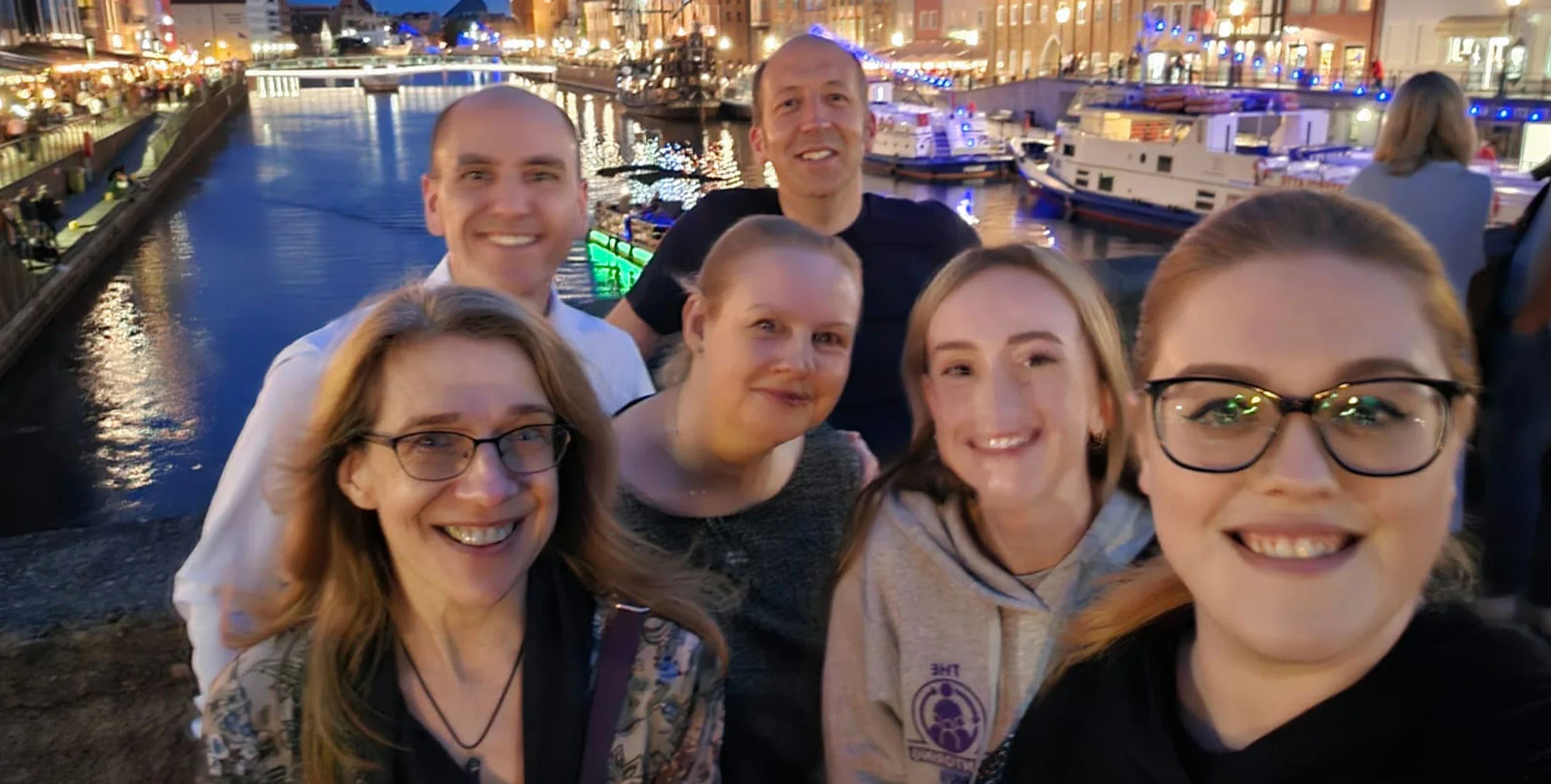 A group of six people posing by water in Gdansk.