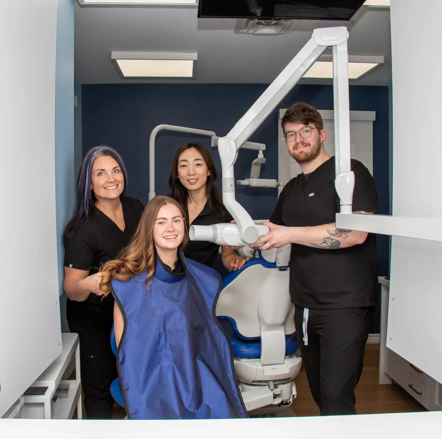 A dental team prepares a patient for an X-ray in a clinic.