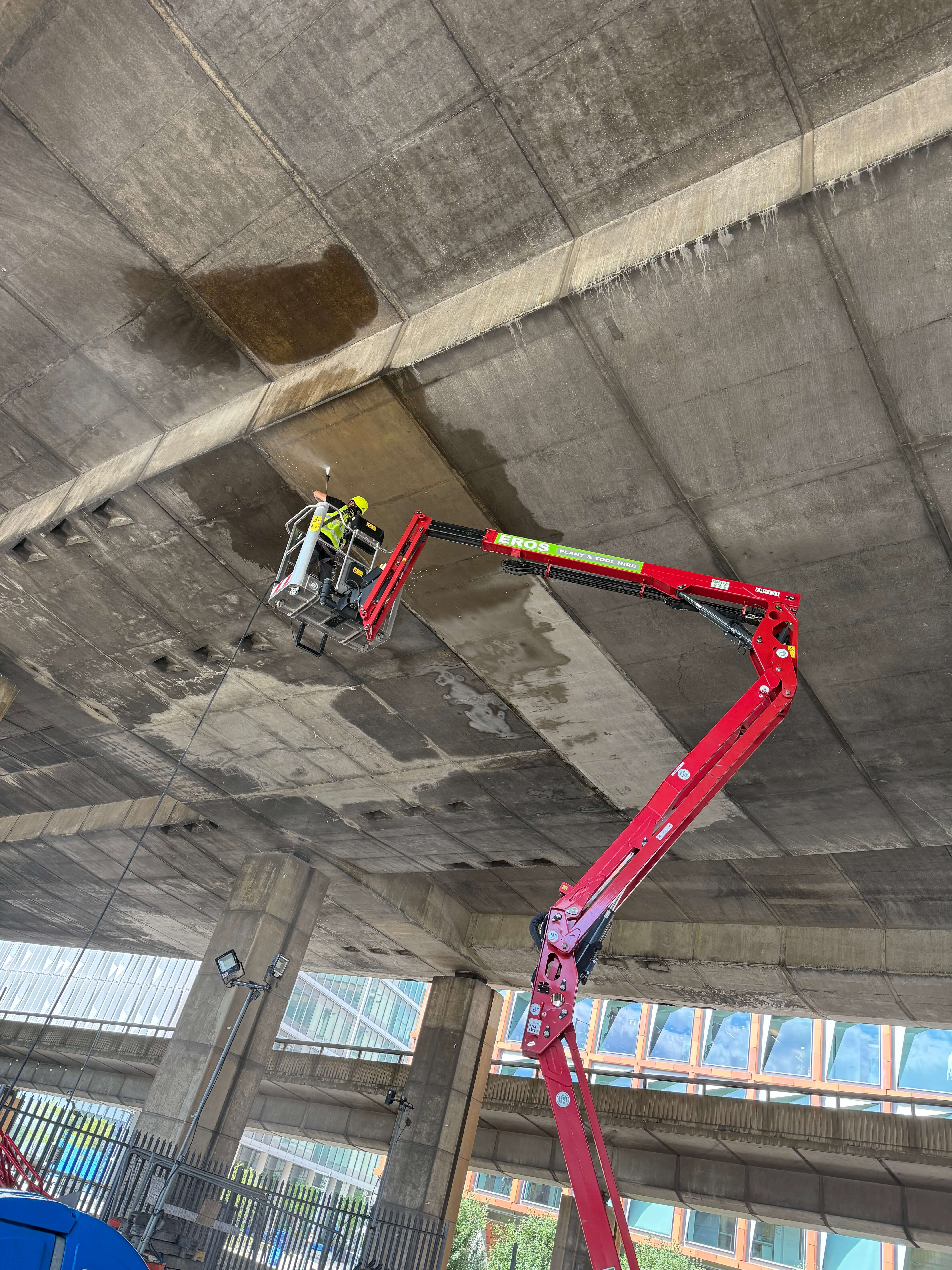 cleaning concrete underpass with water jet wash from a MEWP