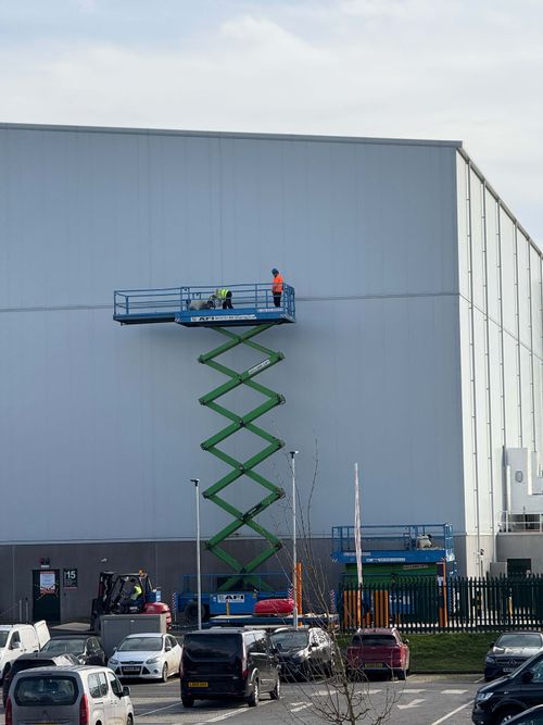 Large-format film studio cladding repainted in weather-resistant coating.