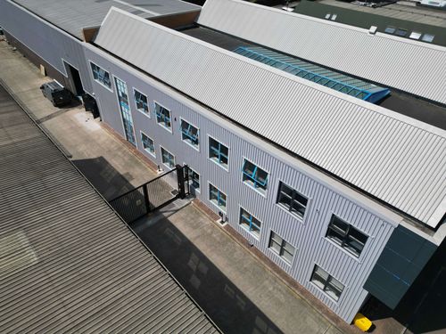 Commercial unit showing masked window frames against grey cladding.