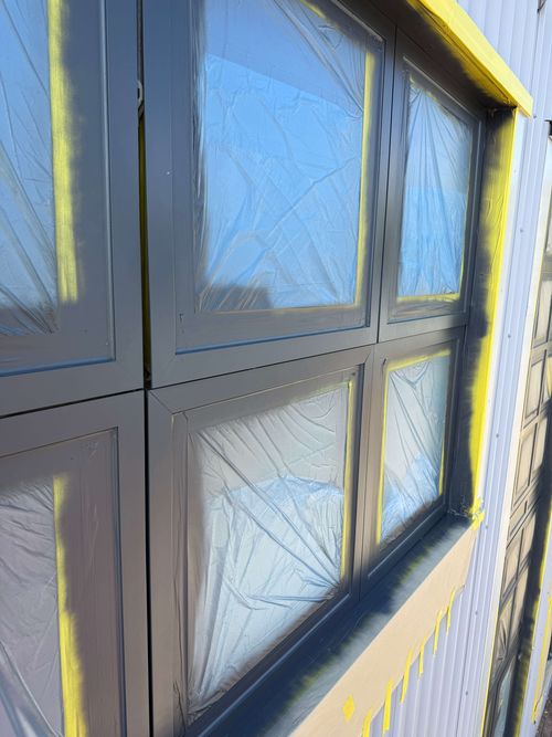 Scissor lift in place as team masks high-level windows.