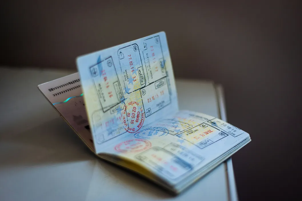 A passport sitting on a table open showing stamps from numerous countries on it