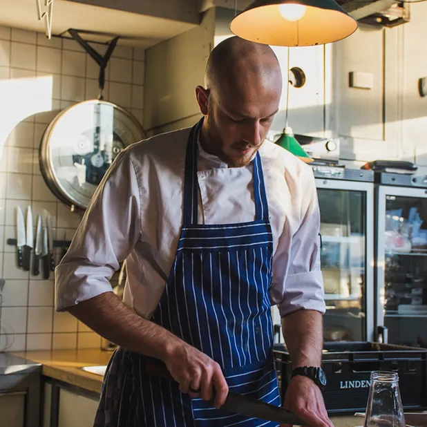 A chef cutting vegetables on a cutting board