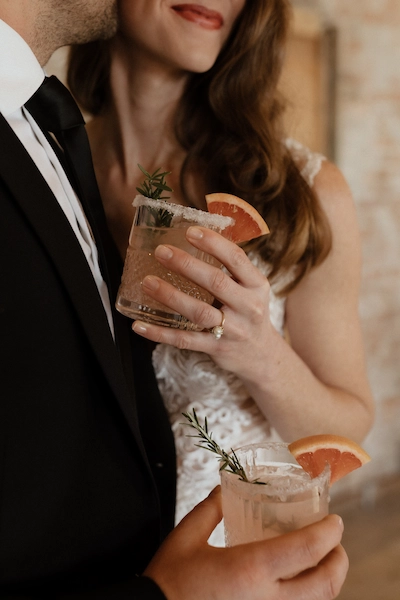closeup of couple holding fancy grapefruit drinks