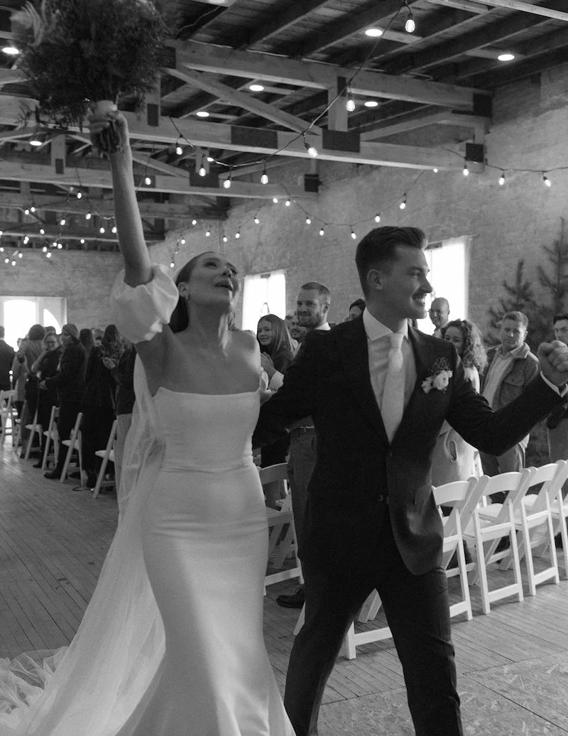 couple celebrating coming down the isle black and white photograph